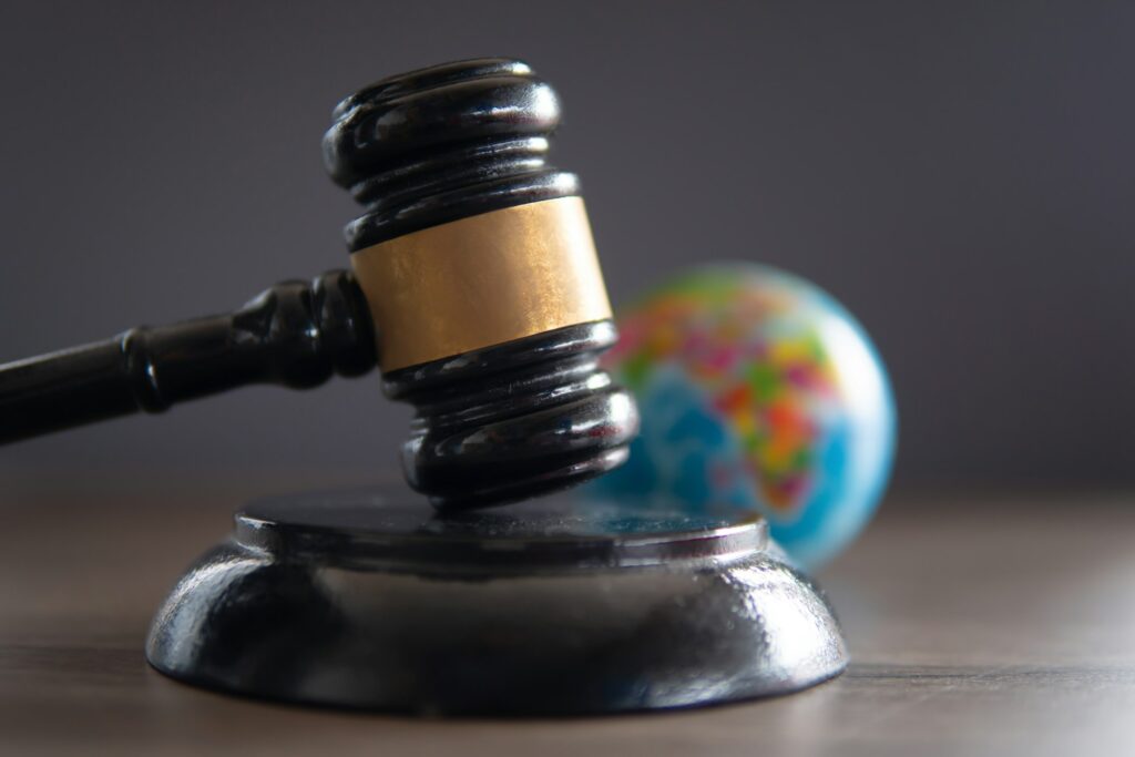 Closeup image of judge gavel and world globe on table.